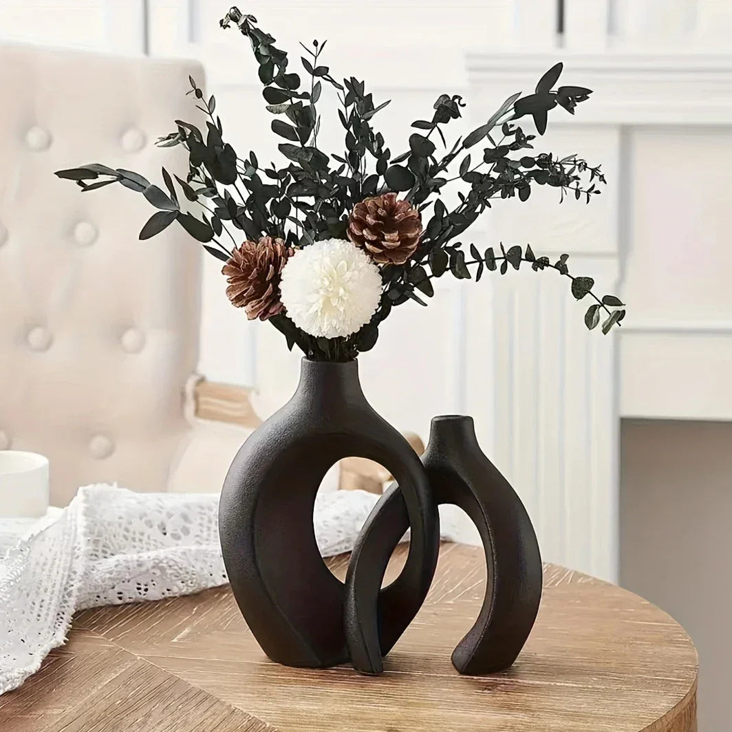 Decorative black vase with floral arrangement on a wooden table