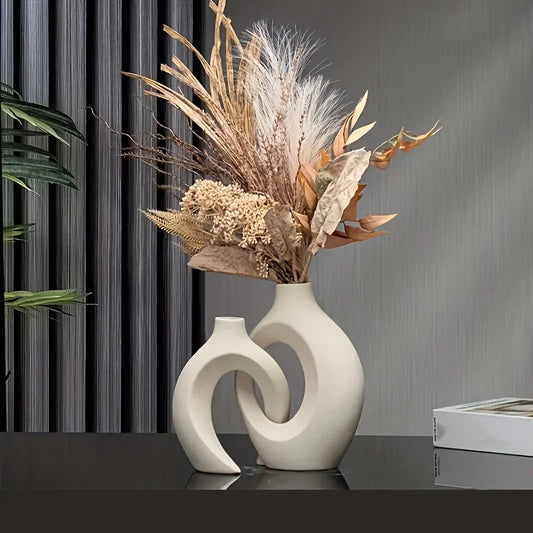 et of two white sculptural vases with curved loop design, modern Nordic interior style.