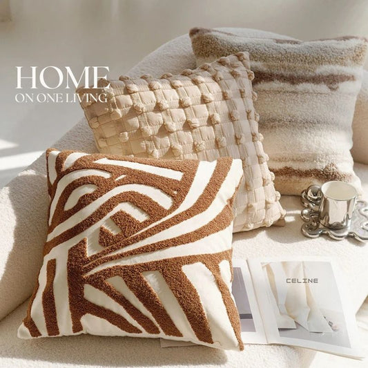 Decorative pillow with brown abstract spiral pattern on white fabric