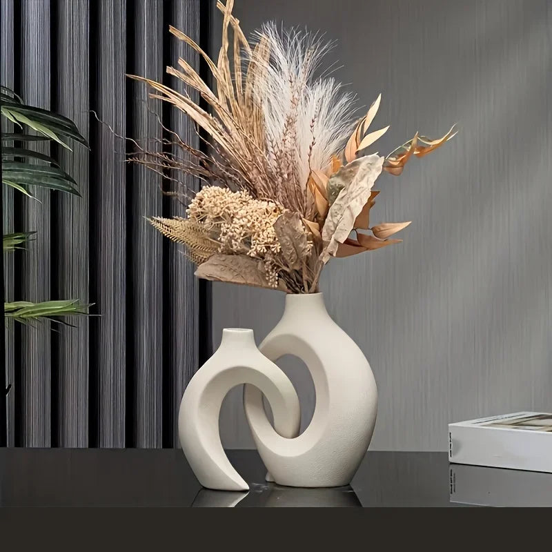 et of two white sculptural vases with curved loop design, modern Nordic interior style.