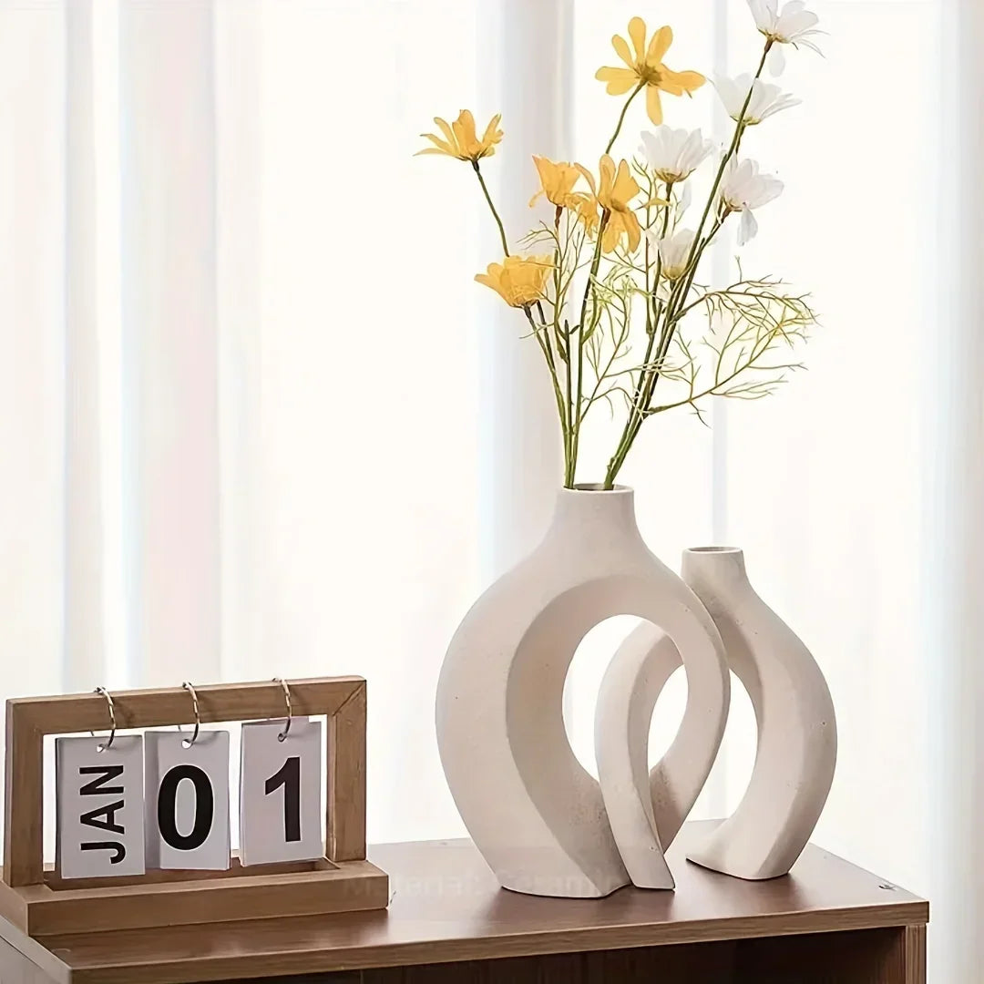 Two white vases with yellow flowers on a wooden surface with a calendar displaying January 1st.